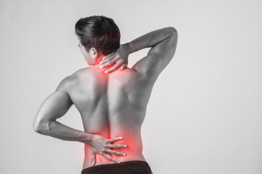 Man with back pain, holding his lower back in distress.
