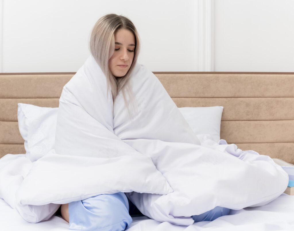 Image of a woman wrapping herself in a blanket.